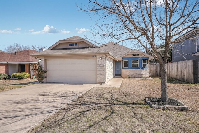 view of front facade featuring roof with shingles, fence, a garage, stone siding, and driveway