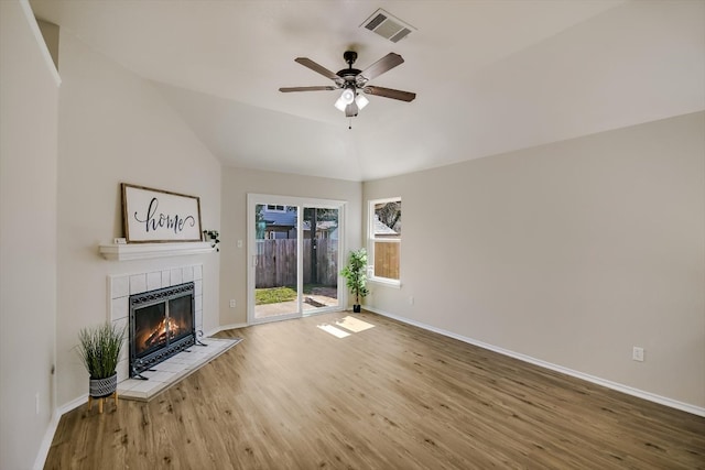 unfurnished living room with baseboards, visible vents, ceiling fan, wood finished floors, and a fireplace