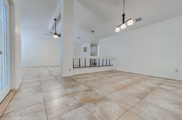 empty room with visible vents, vaulted ceiling with beams, a textured ceiling, and ceiling fan