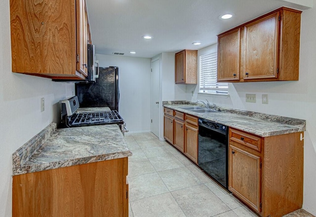 kitchen with appliances with stainless steel finishes, brown cabinetry, a sink, and visible vents