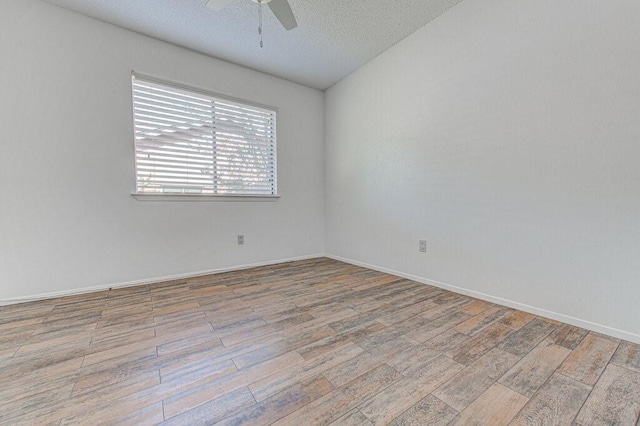 unfurnished room featuring ceiling fan, a textured ceiling, baseboards, and wood finished floors