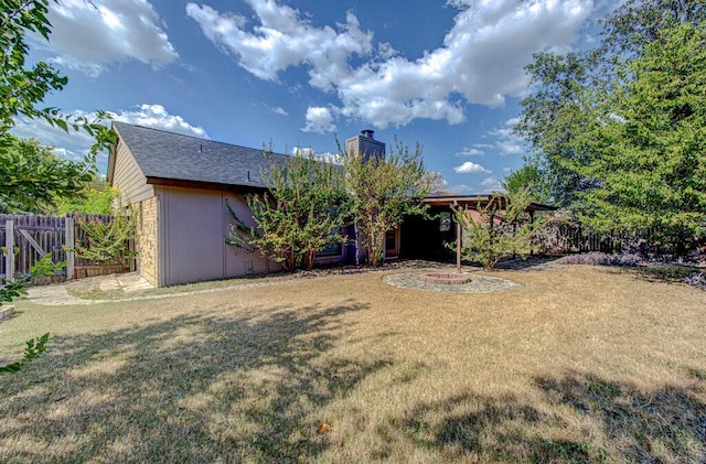 back of house with a chimney, fence, and a lawn