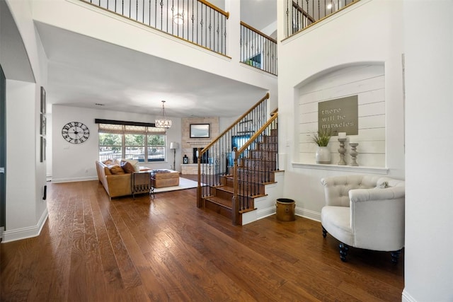 205 Agave Bloom Cv, Austin, TX 78738 - living room featuring hardwood / wood-style floors, stairway, a chandelier, baseboards, and a towering ceiling