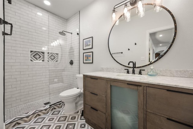 bathroom featuring a shower stall, toilet, and vanity