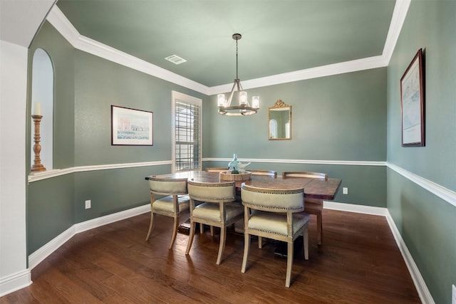 dining room featuring crown molding, wood finished floors, visible vents, and baseboards