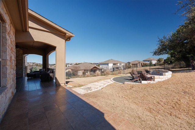 view of yard with a fire pit, a patio area, fence, and a residential view