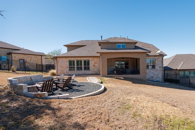 rear view of property with a patio area, fence, a fire pit, and stucco siding