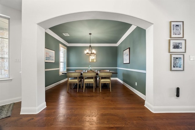 dining space with visible vents, baseboards, wood finished floors, crown molding, and a chandelier