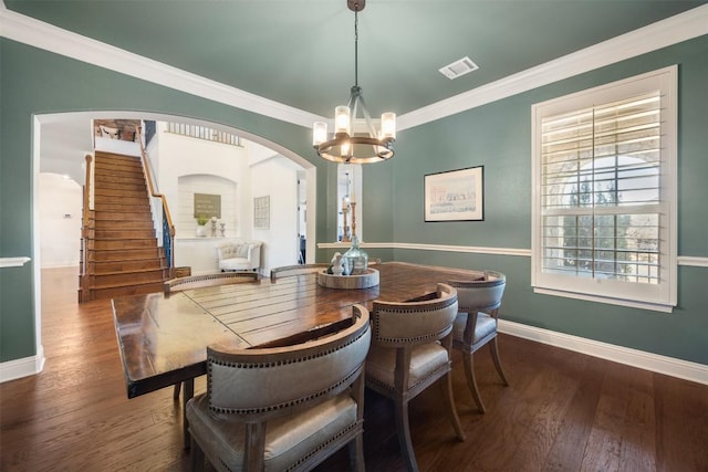 dining area featuring crown molding, visible vents, arched walkways, and hardwood / wood-style floors