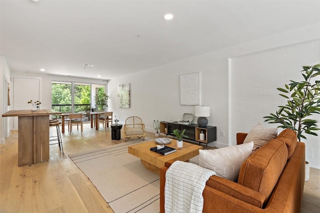 living room featuring light wood-style floors, recessed lighting, and baseboards