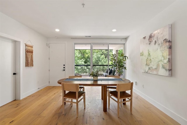 dining space featuring baseboards, light wood-type flooring, and recessed lighting