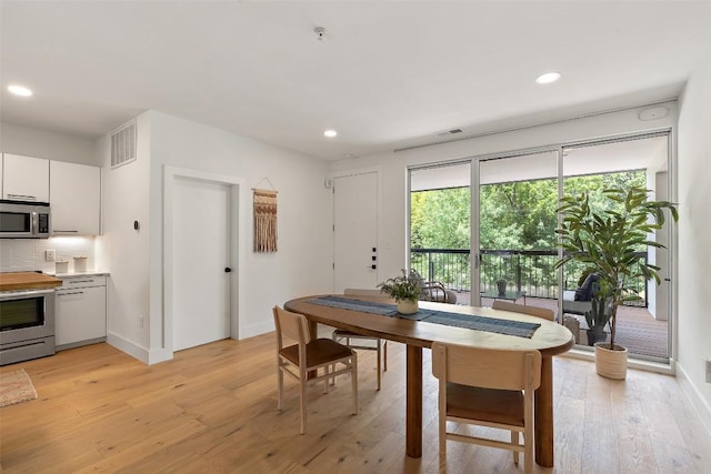 dining room featuring light wood finished floors, baseboards, visible vents, and recessed lighting