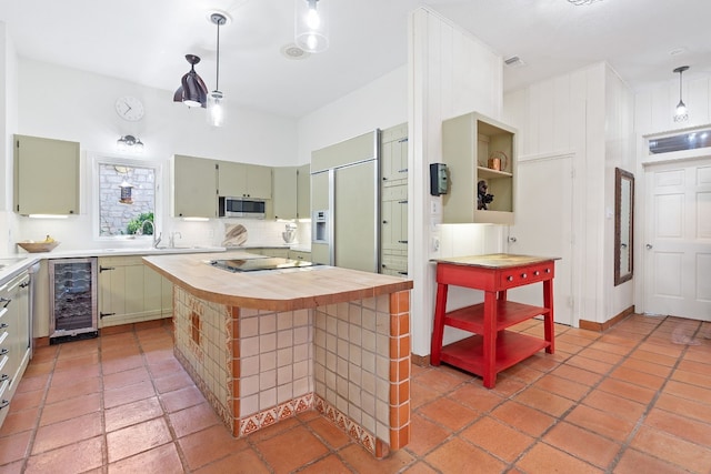 kitchen featuring wine cooler, butcher block countertops, stainless steel microwave, paneled refrigerator, and stovetop