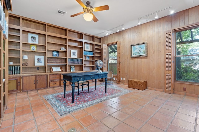 office area featuring plenty of natural light, wooden walls, visible vents, and built in features