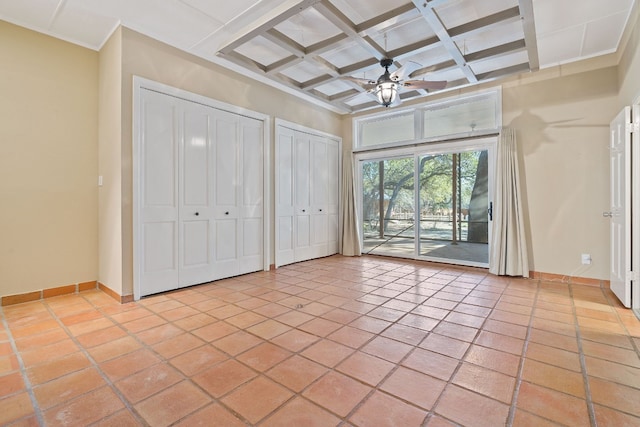 unfurnished bedroom with access to exterior, light tile patterned floors, multiple closets, coffered ceiling, and baseboards