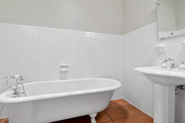 bathroom with a freestanding bath, tile walls, and tile patterned floors