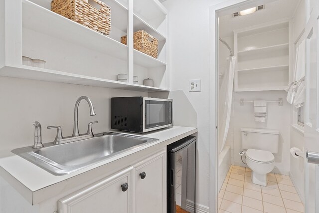 6615 La Concha Pass, Austin, TX 78749 - kitchen featuring stainless steel microwave, beverage cooler, open shelves, a sink, and white cabinets