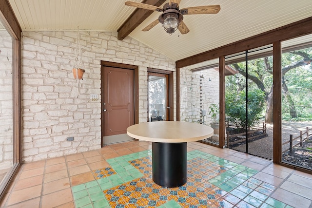 interior space with lofted ceiling with beams and ceiling fan