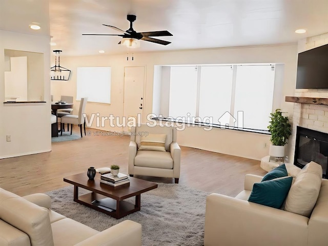 living room featuring a fireplace, a ceiling fan, wood finished floors, and recessed lighting