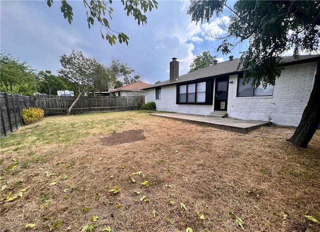 view of yard with entry steps, a patio area, and a fenced backyard