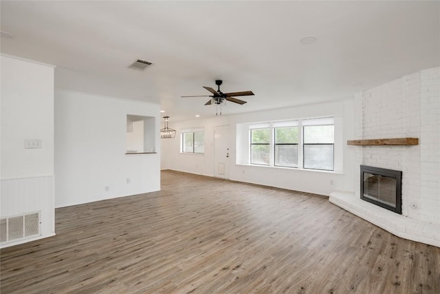 6705 Lancret Hill Dr, Austin, TX 78745 - unfurnished living room featuring wood finished floors, a brick fireplace, and ceiling fan