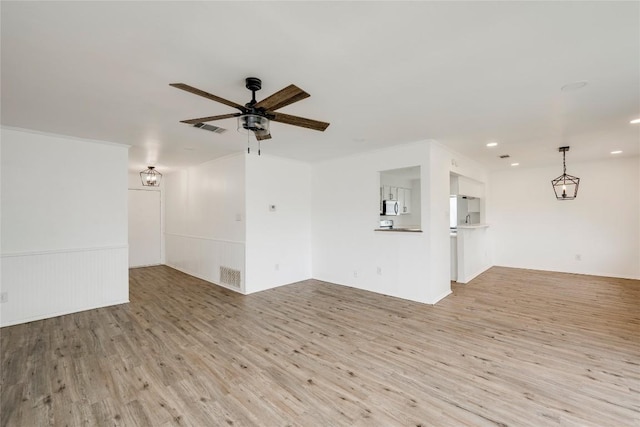 spare room with visible vents, light wood-style flooring, and a ceiling fan