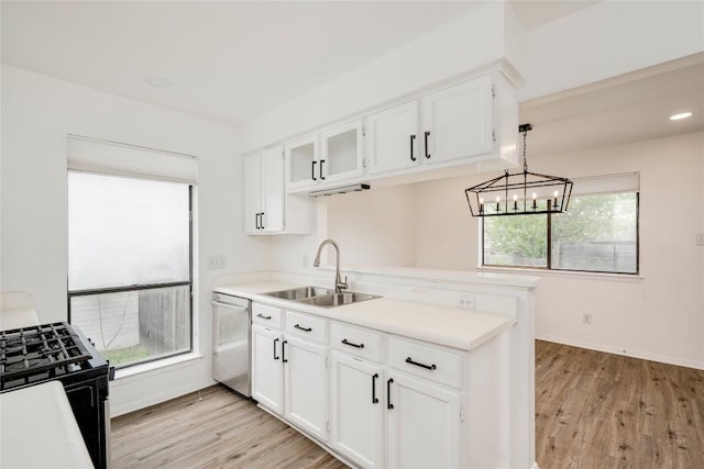kitchen with light countertops, a sink, black gas stove, dishwasher, and a peninsula