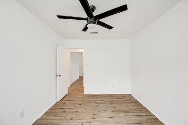 empty room with a ceiling fan, visible vents, and wood finished floors