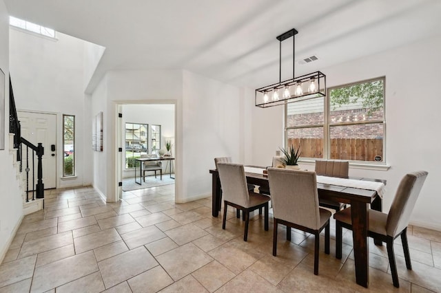 dining room featuring baseboards, stairs, and visible vents