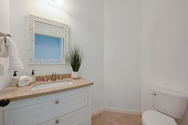 bathroom featuring toilet, tile patterned flooring, baseboards, and vanity