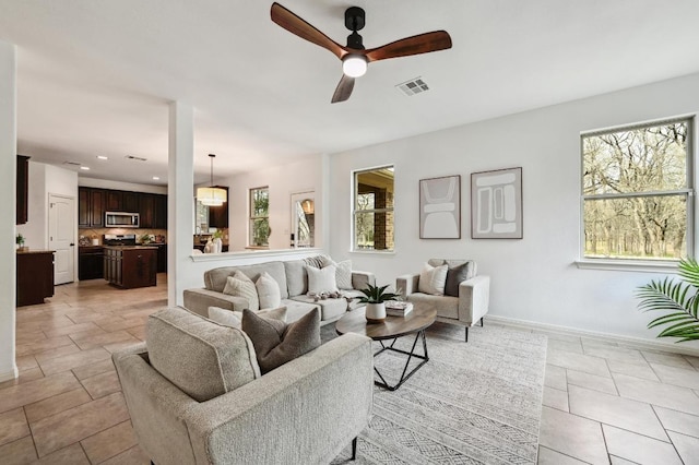 living area featuring recessed lighting, visible vents, ceiling fan, and baseboards