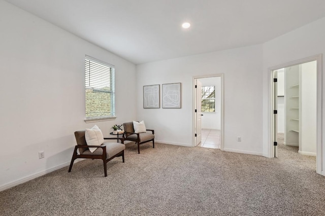 living area featuring light carpet, recessed lighting, and baseboards