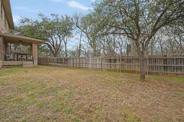 view of yard featuring ceiling fan and fence