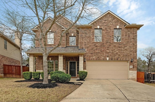 view of front of property featuring brick siding, fence, a garage, stone siding, and driveway