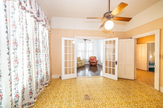 unfurnished room with baseboards, a ceiling fan, crown molding, and french doors