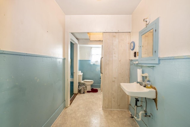 bathroom with wainscoting, a sink, and toilet