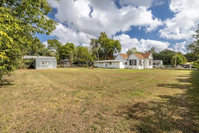 view of yard with a shed, fence, and an outdoor structure