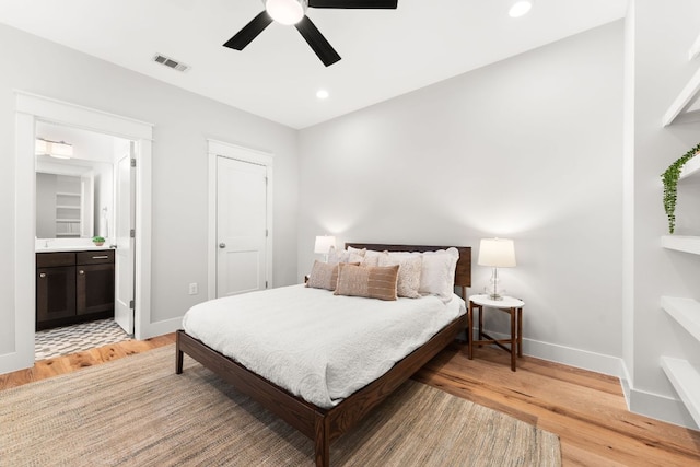 bedroom featuring visible vents, baseboards, ensuite bath, light wood-style flooring, and recessed lighting