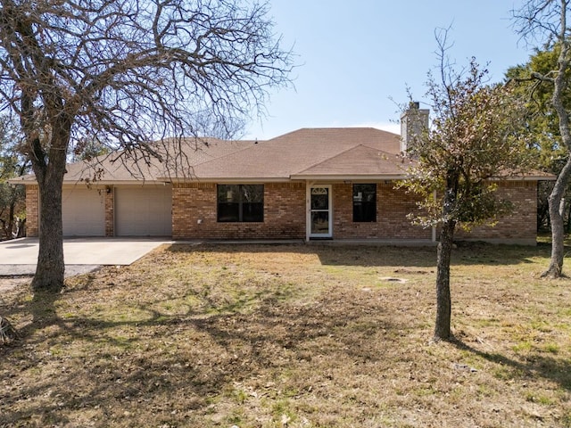 ranch-style home featuring a garage, brick siding, concrete driveway, a chimney, and a front yard