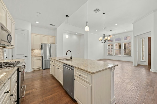 102 Gallia Dr Unit 3, Austin, TX 78734 - kitchen featuring appliances with stainless steel finishes, cream cabinets, backsplash, a chandelier, and dark wood-type flooring
