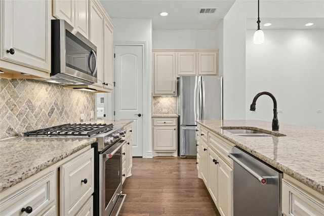 kitchen featuring a sink, visible vents, appliances with stainless steel finishes, dark wood finished floors, and decorative light fixtures