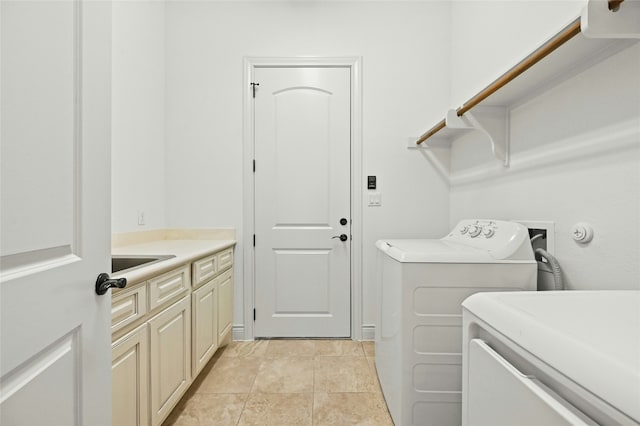 clothes washing area featuring cabinet space, washer and clothes dryer, and light tile patterned floors