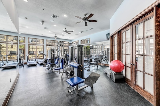 exercise room with a textured ceiling, french doors, visible vents, and a wealth of natural light