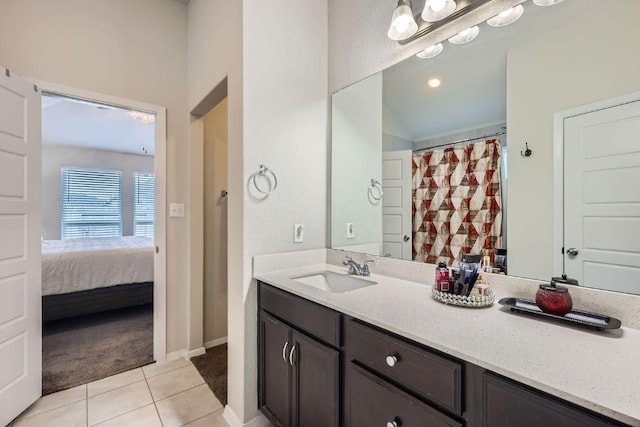 ensuite bathroom featuring ensuite bath, vanity, baseboards, and tile patterned floors