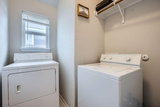 washroom with a textured wall, laundry area, independent washer and dryer, and baseboards