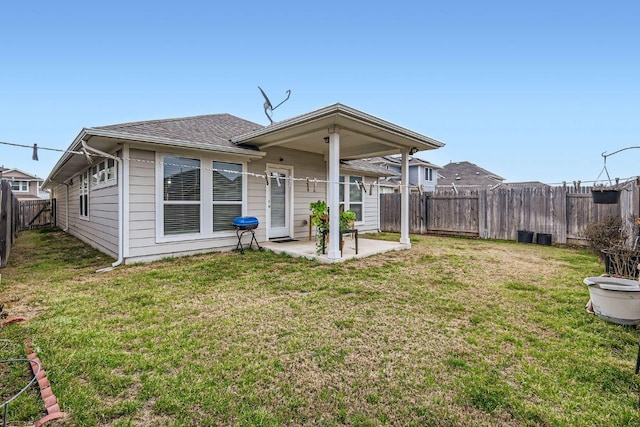 back of house featuring a patio area, a lawn, a fenced backyard, and roof with shingles