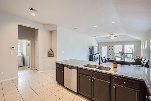 281 Gaida Loop, Georgetown, TX 78628 - kitchen with stainless steel dishwasher, washer / clothes dryer, ceiling fan, lofted ceiling, and dark brown cabinets