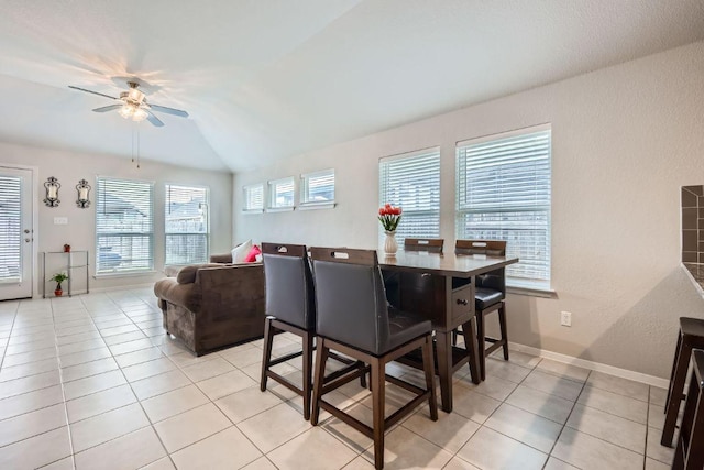 dining room with light tile patterned floors, vaulted ceiling, a ceiling fan, and baseboards