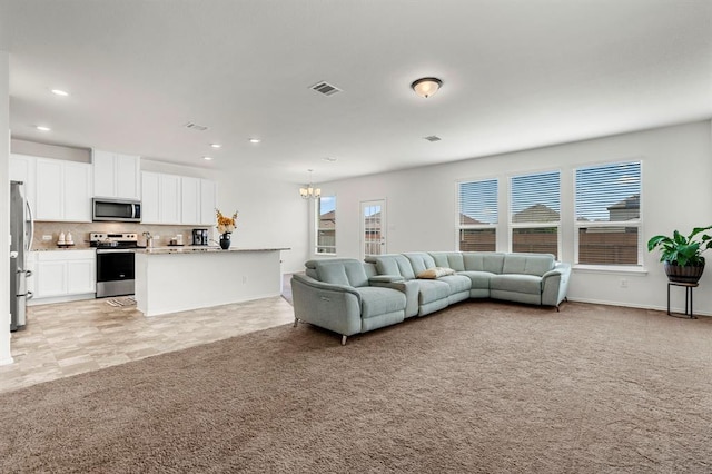 living room with recessed lighting, visible vents, light carpet, a chandelier, and baseboards