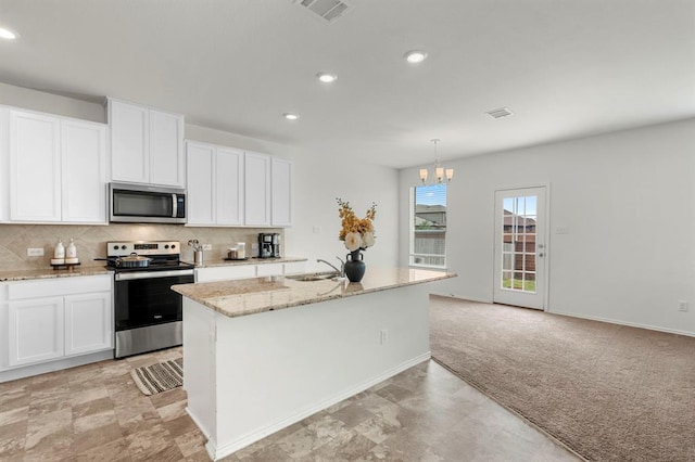 kitchen with appliances with stainless steel finishes, light colored carpet, visible vents, and backsplash